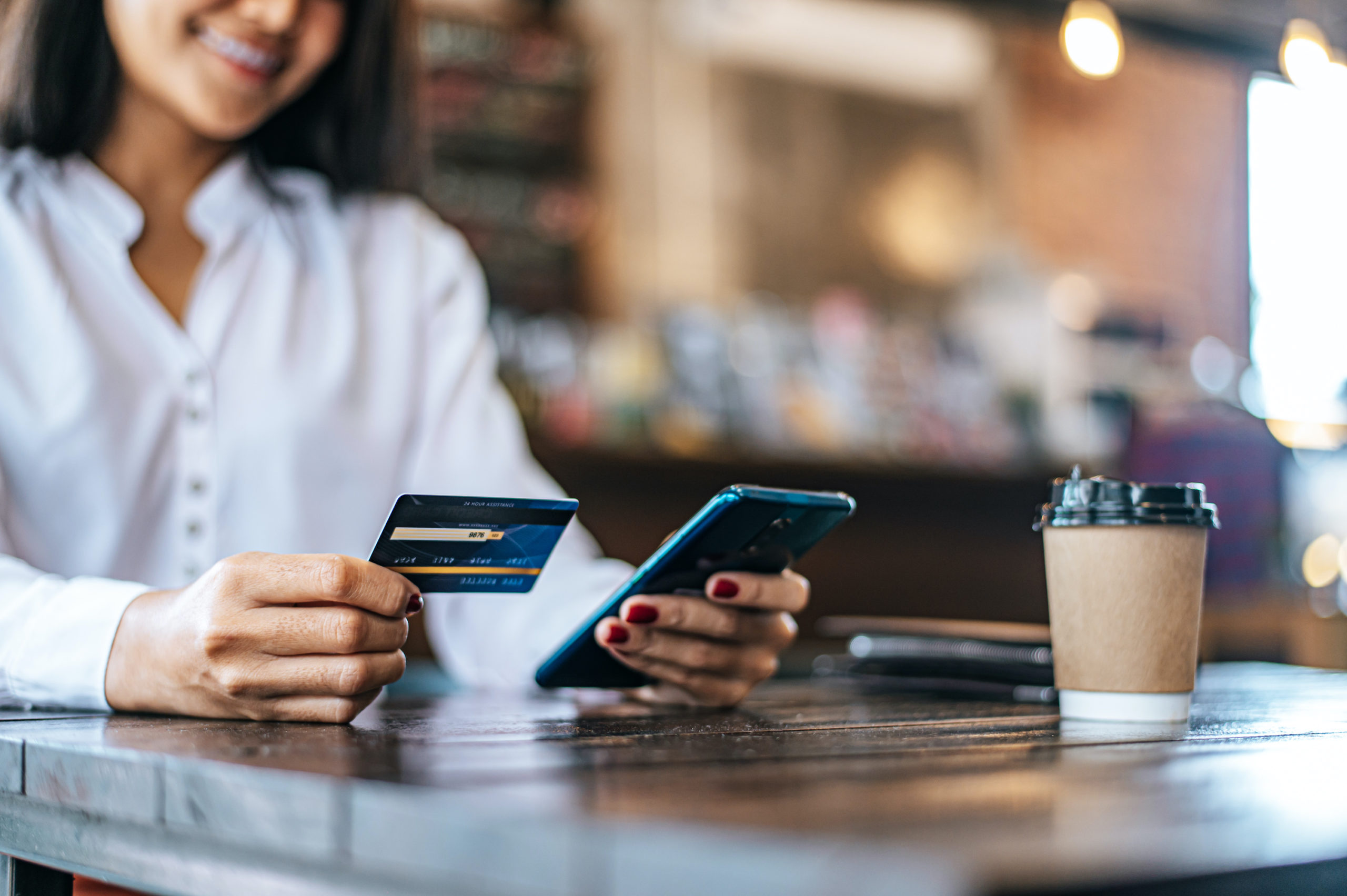 woman on phone with credit card paying