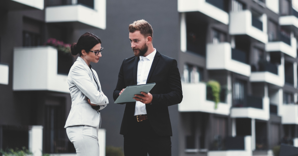 real estate agents discussing in front of building