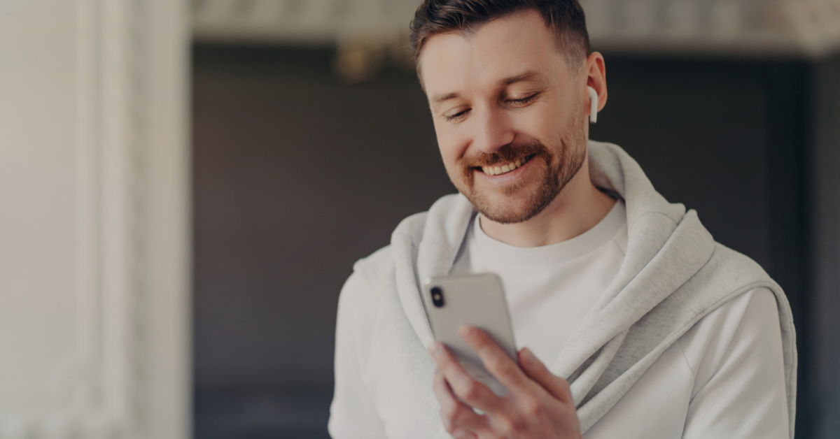 man looking at phone with airpods in